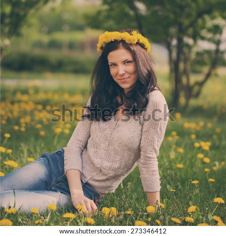 pretty woman on dandelions field, happy cheerful girl resting on dandelions meadow, relaxation outdoor in springtime, toned image