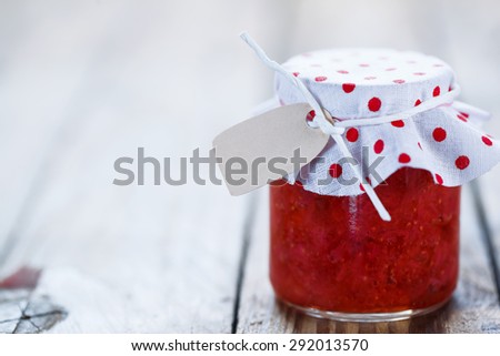 Fresh strawberry homemade jam in jar on white wood background. healthy organic and vegan food.