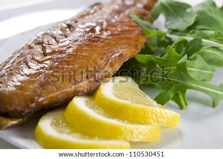 Smoked mackerel fish with lemon and salad