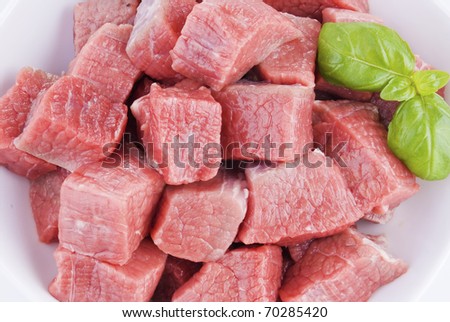 Bowl of diced beef over white background - close up