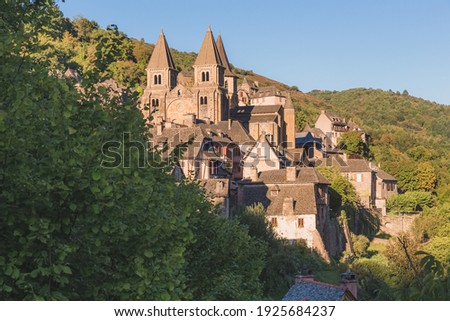 The quaint and charming medieval French village of Conques, Aveyron, and Abbey Church of Sainte-Foy, a popular summer tourist destination in the Occitanie region of France. Photo stock © 