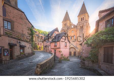 The quaint and charming medieval old town centre of the medieval French village Conques, Aveyron and Abbey Church of Sainte-Foy at sunset or sunrise in Occitanie, France. Photo stock © 