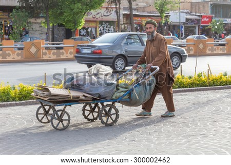 SHIRAZ, IRAN - APRIL 25, 2015: an unidentified man pushes a cart in the streets of Shira, Iran