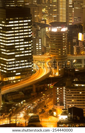 OSAKA, JAPAN - DECEMBER 26: Night scene of Gate Tower Building with cars ride through. It is notable for the highway that passes through the building. This building also known as \