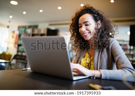Young beautiful student girl working, learning in college library