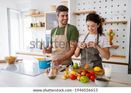 Happy young couple preparing food in kitchen at home 商業照片 © 