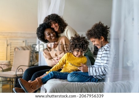 Happy lesbian multiethnic couple in love with childen at home. Family lgbt child happiness concept