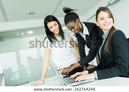 Businesswomen exchanging thoughts in a nice office environment while working on a laptop