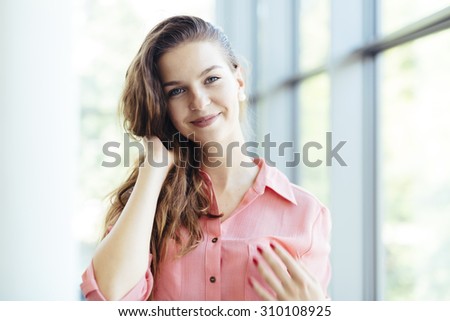 Beautiful businesswoman holding her hair and smiling. Feeling of content