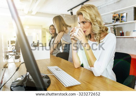 Beautiful businesswoman drinking coffee to stay alert and focused at work