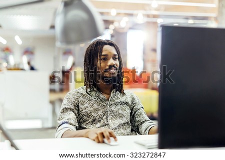 Handsome designer working on a computer in a well lit office