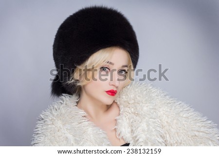 Winter Woman in Luxury Fur Coat. Beauty Fashion Model Girl. Beautiful winter girl in winter knitted hat and scarf