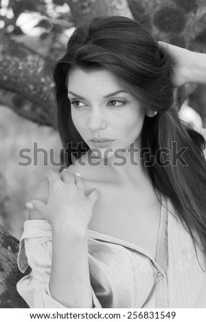 Portrait of young beautiful woman with bare shoulders , on green background summer nature. Black and White