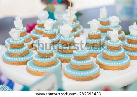 Elegant sweet table with big cake, cupcakes, cake pops on dinner or event party. Cake pops. Tray with delicious cakes and macaroon