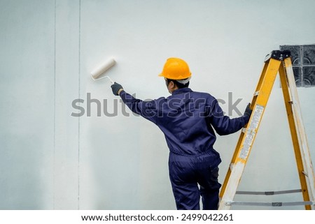 Image, Stock Photo painter stands with paint roller on a ladder to paint the corner of a room window with white color. do it yourself concept image