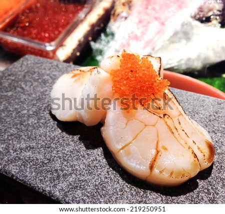 Scallop(Hotate) sushi topped with ebiko, serves on stone plate