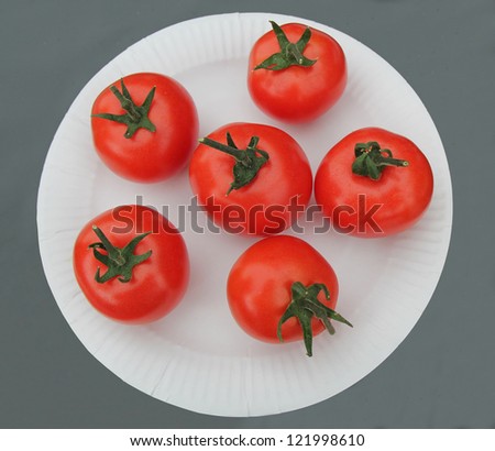 Six Display Red Tomatoes on a White Paper Plate.