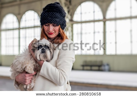 Elegant ginger hair woman with shih tzu dog at the Vitebsk railway station in St.-Petersburg, Russia.