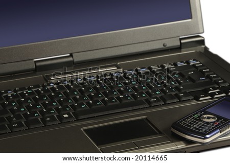 mobile phone on keyboard of laptop
