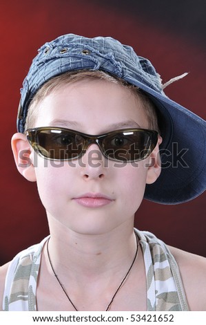 portrait of is ten years old boy in a jean cap and sun glasses