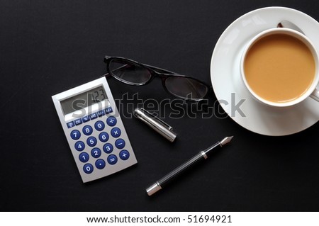 business breakfast in the office on black desktop with calculator pen and glasses