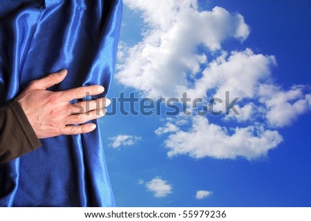 blue sky behind curtain and hand with copyspace fpr text message