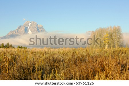 Ground fog surrounds the Grand Teton mountain range in Jackson Hole Wyoming.