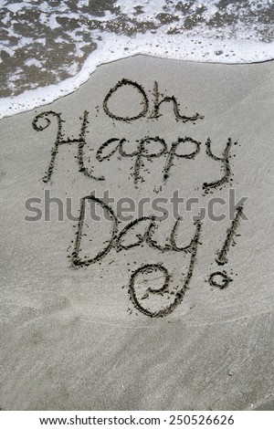 Black sand surf with a message;  Oh happy day , written in the sand