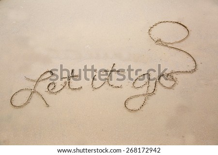 Let it go written in cursive in the sand including a drawn balloon; message in the sand, let It go????