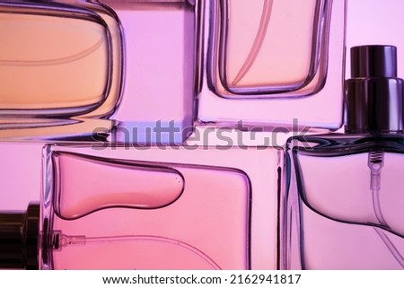 Top view, flat lay of a set of perfume bottles on a purple background.