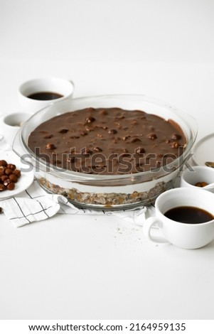 trifle with biscuit, caramel, nuts, cream and chocolate in glass round deko, ingredients on table, dessert or sweets for holiday, white background, close up, flat lay with copy space Stok fotoğraf © 