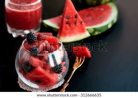 Summer fruit salad of watermelon flesh in a glass piala, slices of watermelon and blackberries, toned image, selective focus