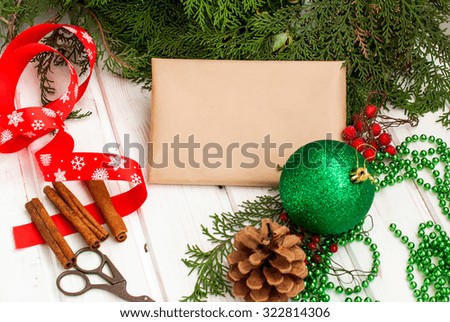 step by step photo decoration New Year gift ribbons, branches and berries, fir branch, colorful ribbons, cones and nuts on an old wooden board, rozhdestveskaya card, toned image, selective focus