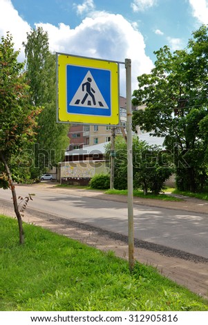 Road sign -pedestrian crossing- on city street in sunny day