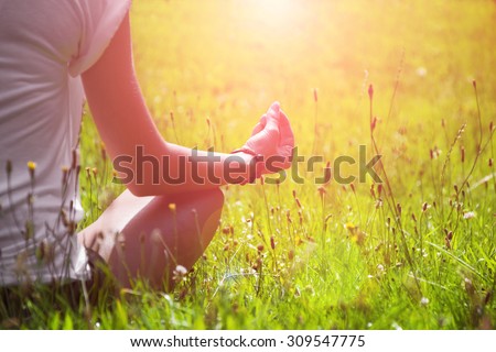 Young woman during relaxation and meditation in park meditation session. Frame shows half of body.
