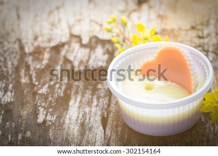 Thai dessert, thai coconut jelly on  wood plank with yellow flower. vitage color.