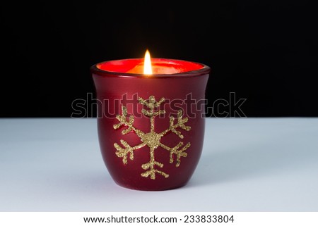Christmas colored candle with flame on