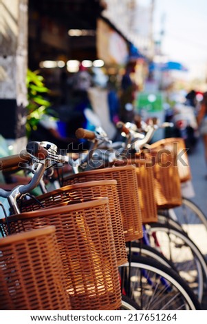 Parked bikes with wicker baskets for rent by tourists