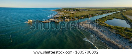 beautiful panorama of the valleys near Ravenna (Fiumi Uniti) where the river flows into the sea with the typical fishermen's huts at sunset Foto stock © 