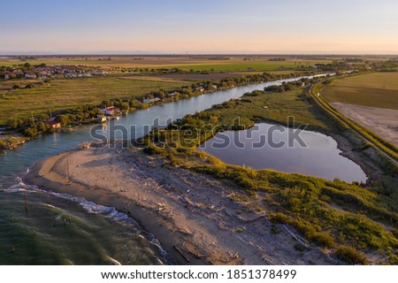 beautiful landscapes of the valleys near Ravenna ,Fiumi Uniti, where the river flows into the sea with the typical fishermen's huts at sunset Foto stock © 