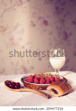 Healthy breakfast with milk and croissants. Fresh tasty berries. Vintage toning. Copyspace.