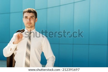 Young handsome successful bussiness man in suit speaking over the phone