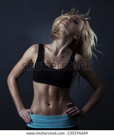 Sport  blond woman with wavy hair showing her well trained body and strong abs.