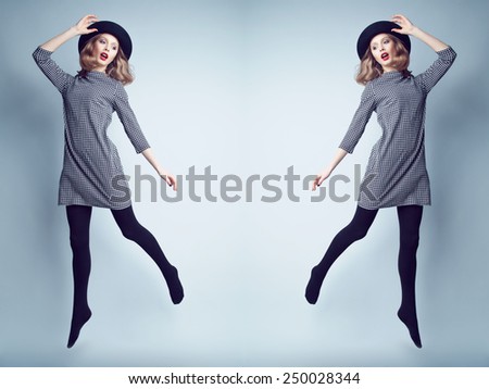 Fashion portrait of young beautiful female model  in casual trendy dress and hat jumping and flying.