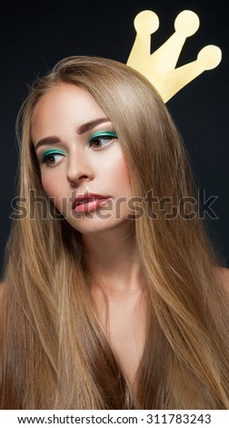 Pretty young woman with fresh clean skin and perfect make up with crown.