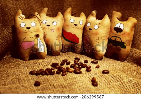 Rag doll handcrafted coffee cats on the background with coffee beans. Cute and funny faces.