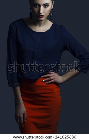 High fashion look. Portrait of a fashionable model with sexy red lips, beautiful red skirt and blue shirt. Close up. Studio shot