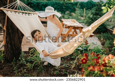 Foto Bild Junge sitzt in Hängematte und liest zu Hause Buch