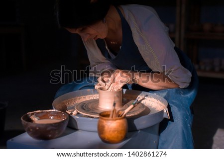 Charming artisan master making ceramic pot on the pottery wheel . Hand work. Stock fotó © 
