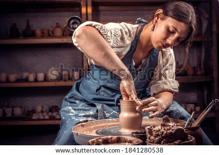 Charming craftsman master sculptor works with clay on a Potter's wheel and at the table with the tools. Handicraft production. Stock fotó © 
